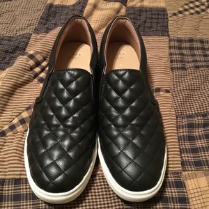 Women’s black slip on shoes.